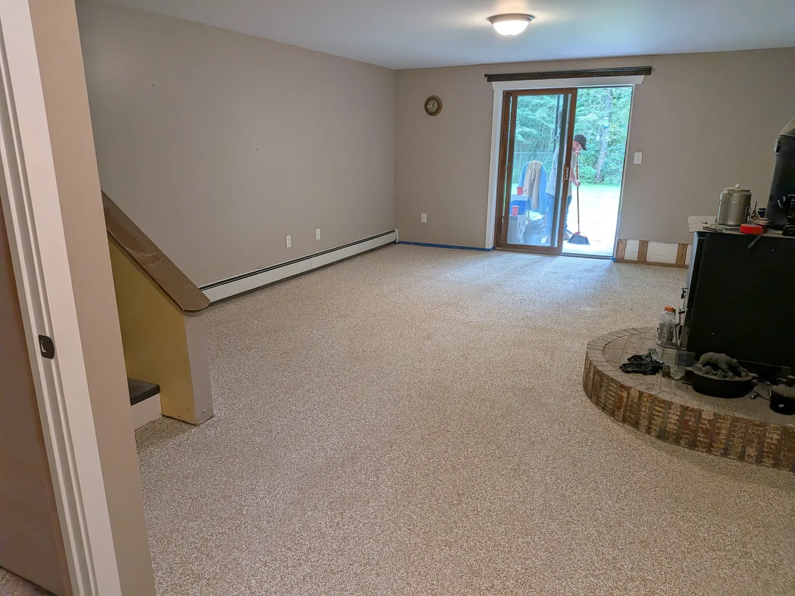 The same flake epoxy living-room floor seen from the stairwell, sliding door to the yard at the far wall.