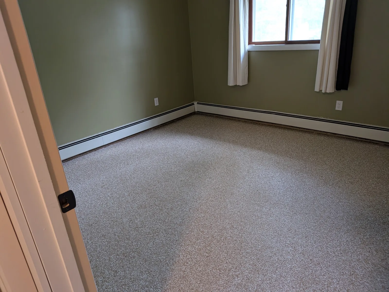 Bedroom with green walls and a finished flake epoxy floor coated wall to wall under the baseboard heat.