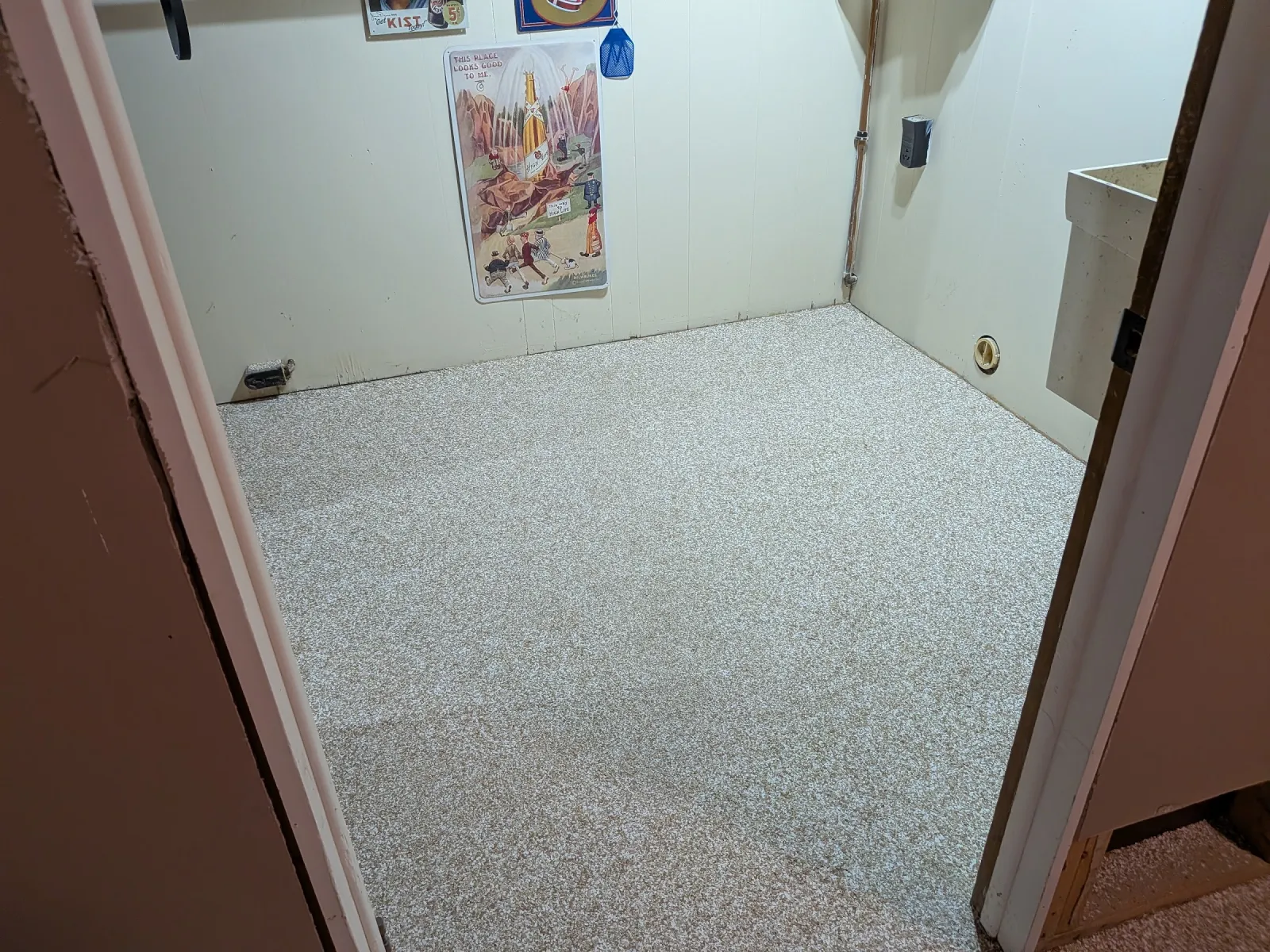 Small back room with a finished flake epoxy floor coated corner to corner up to the wall.