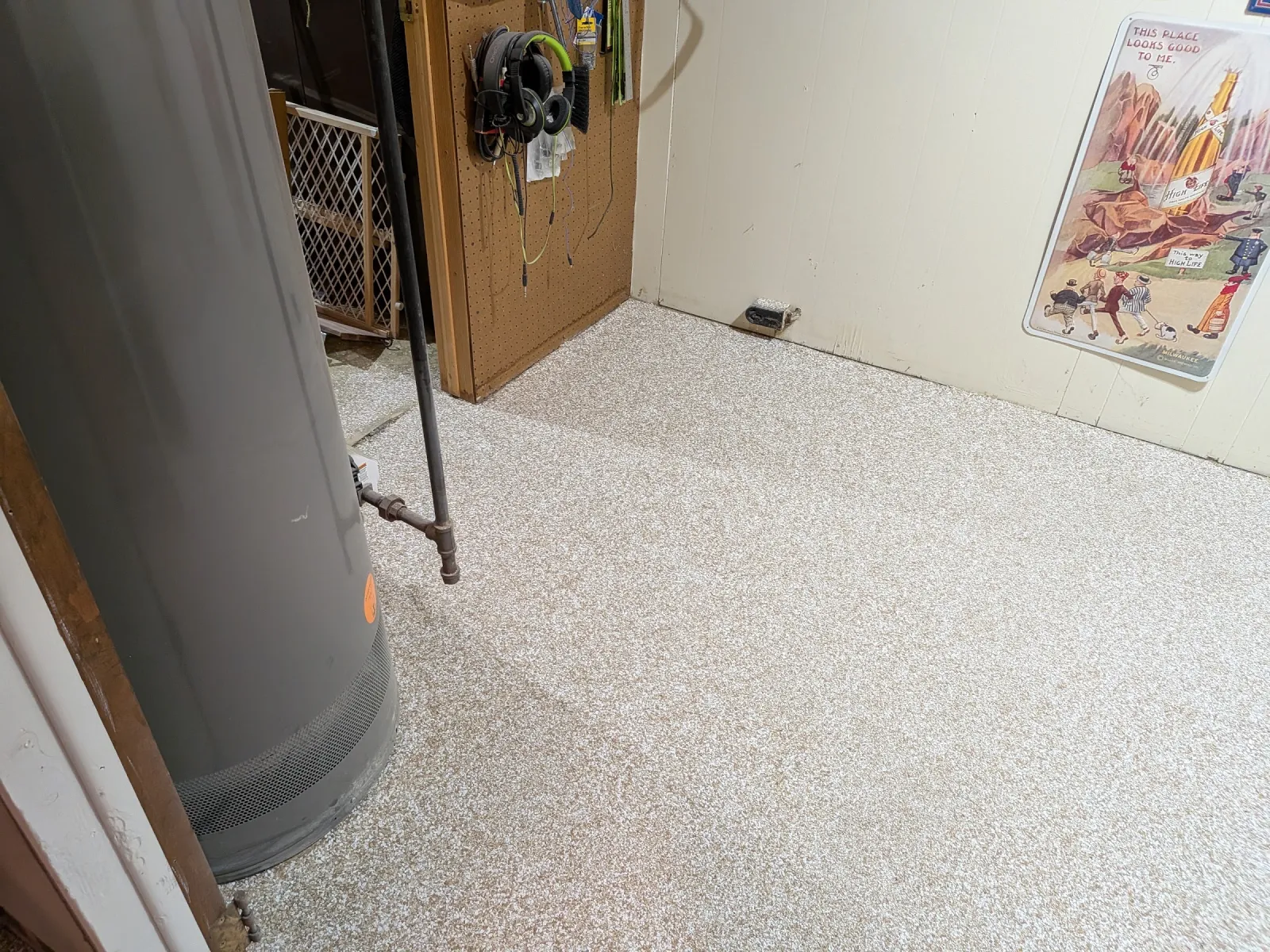 Utility room floor in flake epoxy cut in neatly around a furnace duct and standing pipe.