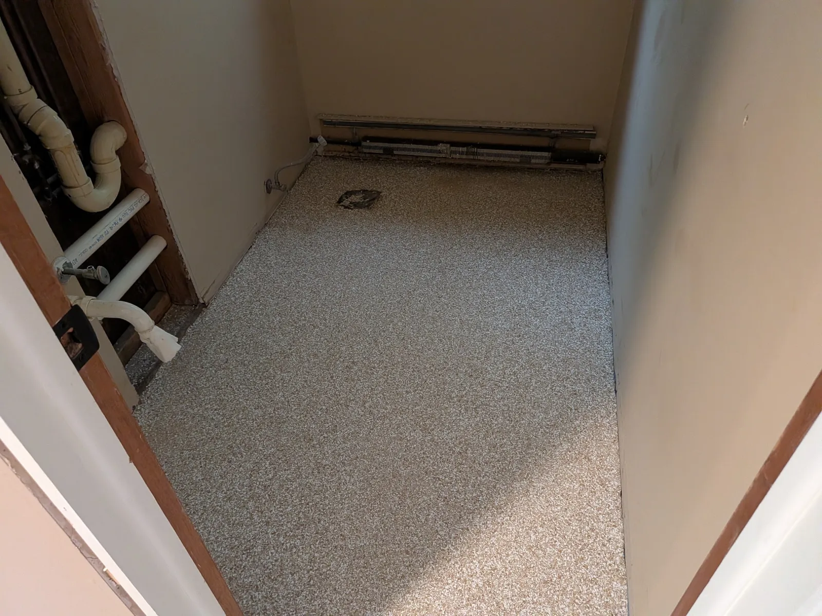 Narrow mechanical closet with the flake epoxy floor coated tight to the baseboard heating and plumbing.